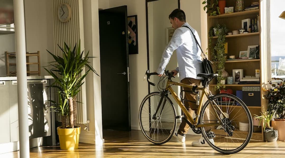 Man leaving apartment with bike
