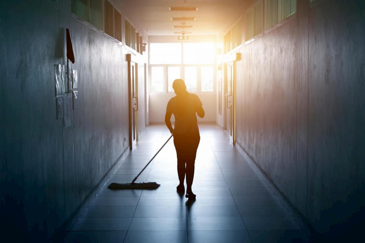 cleaner mopping office floor after work hours