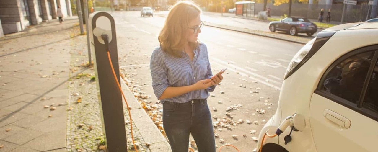 woman standing at electric car charger